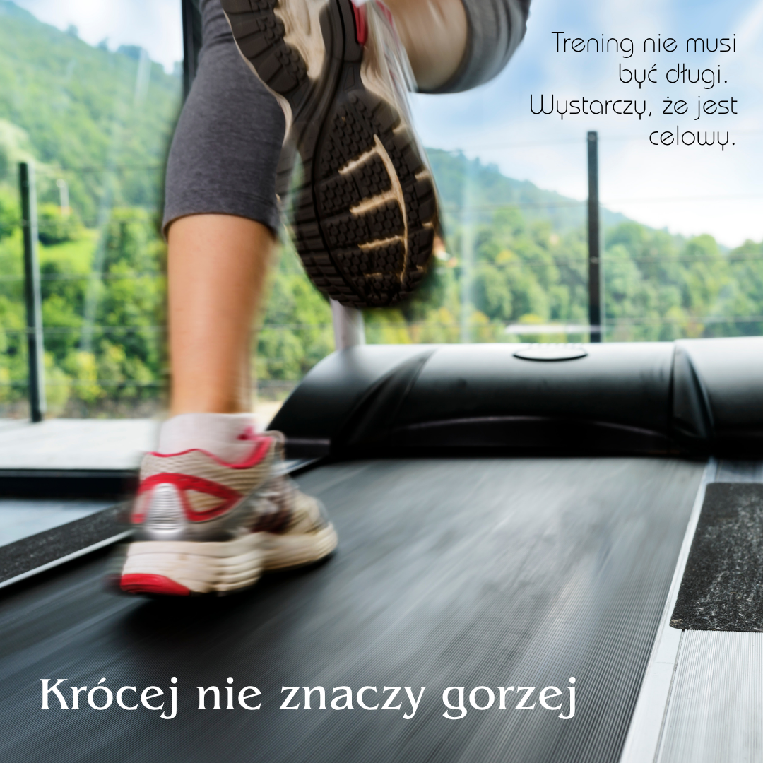 Zbliżenie na nogi osoby biegnącej na bieżni w sportowych butach. W tle widok na zielone wzgórza za dużym oknem. Na grafice widnieje napis: „Trening nie musi być długi. Wystarczy, że jest celowy” oraz „Krócej nie znaczy gorzej”.